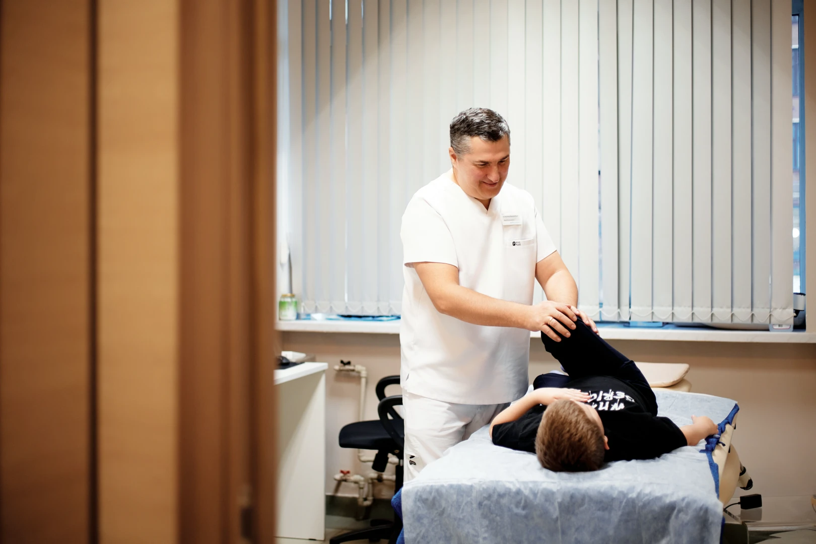 Кинезиолог проводит осмотр пациента на приёме в Ист Клинике
