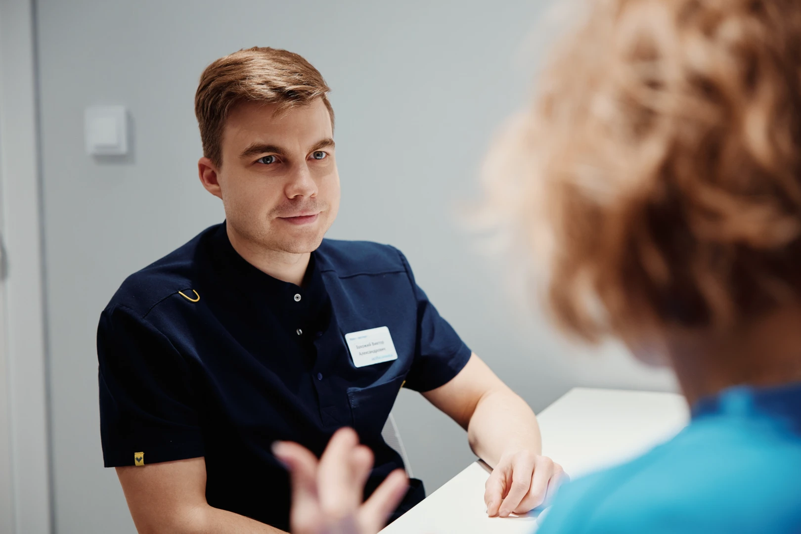 Специалист ЛФК обсуждает с пациентом план лечения