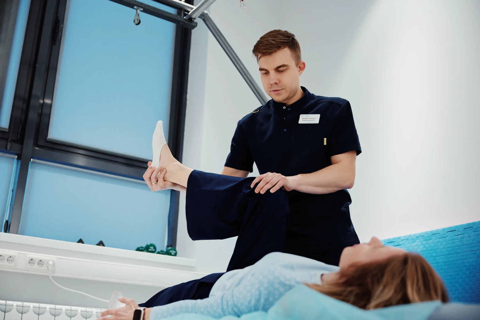 Врач ЛФК проводит беседу и диагностику пациента перед занятием