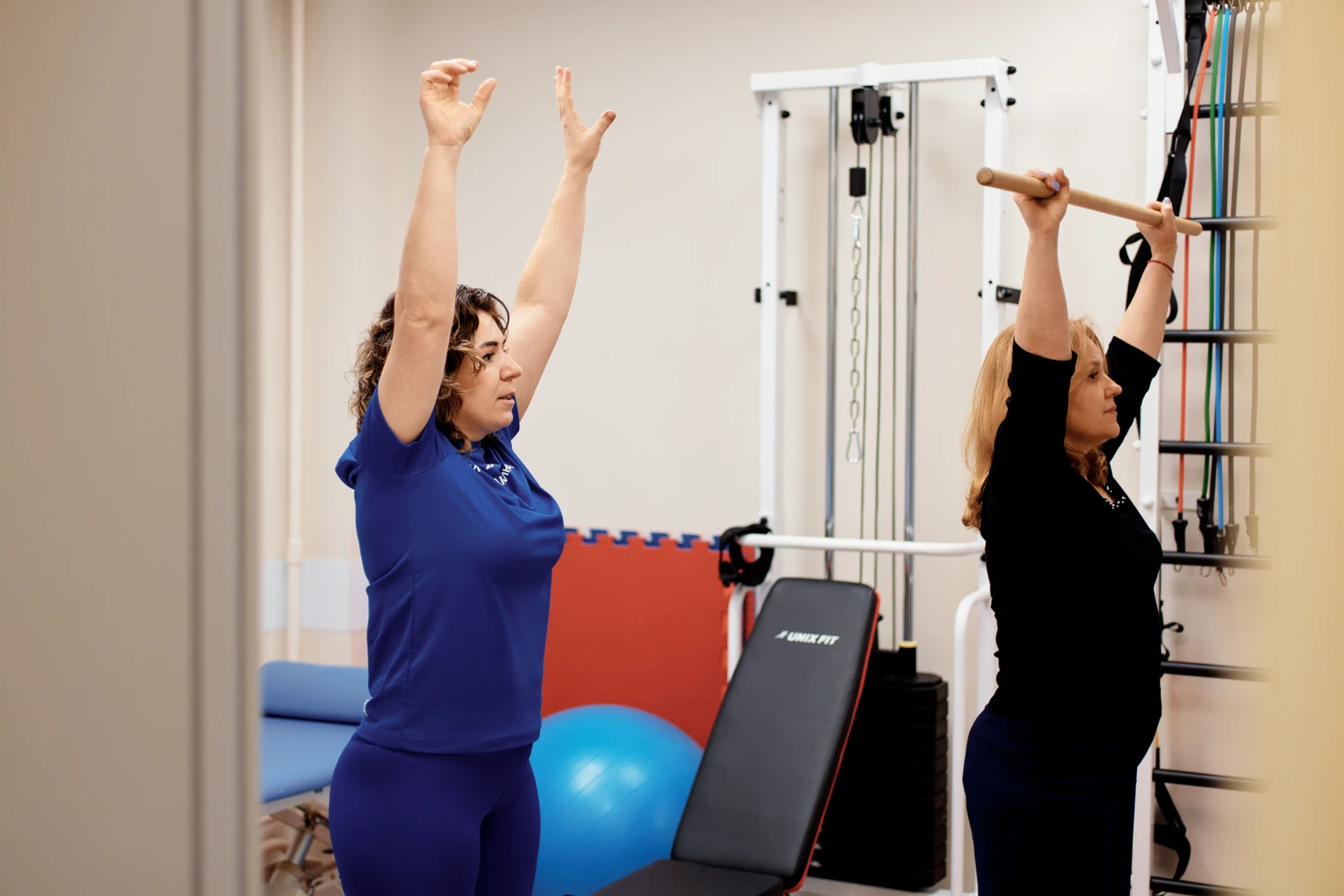 Инструктор ЛФК показывает пациенту упражнение