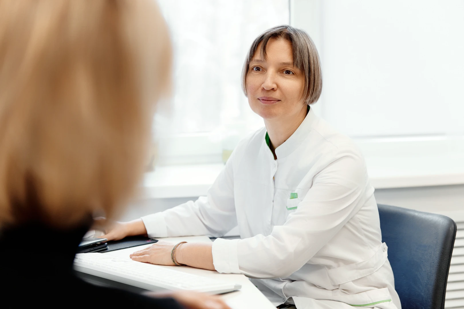 Врач проводит первичный прием перед иглоукалыванием при остеохондрозе