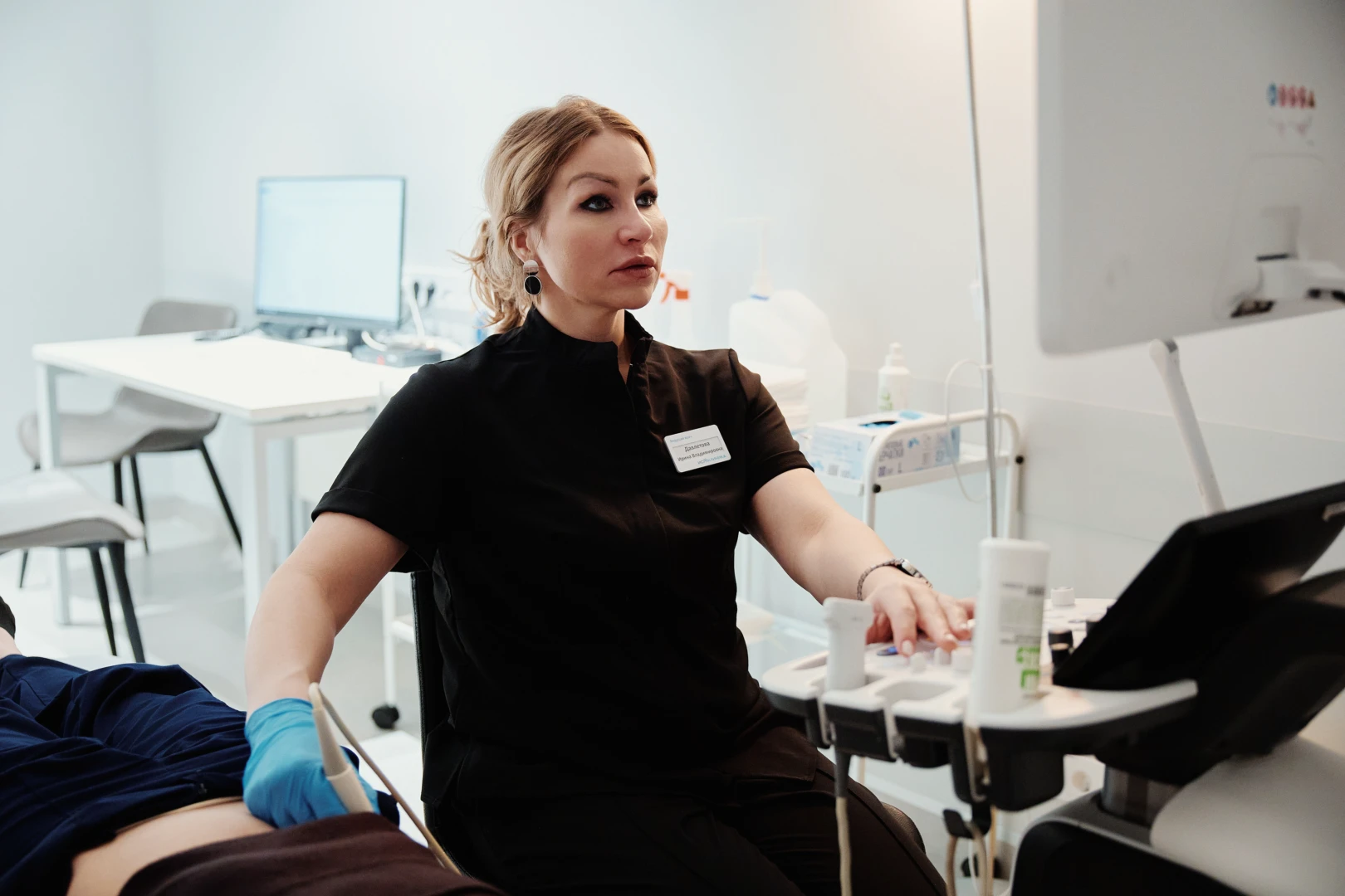 Врач проводит УЗДГ сосудов шеи пациенту