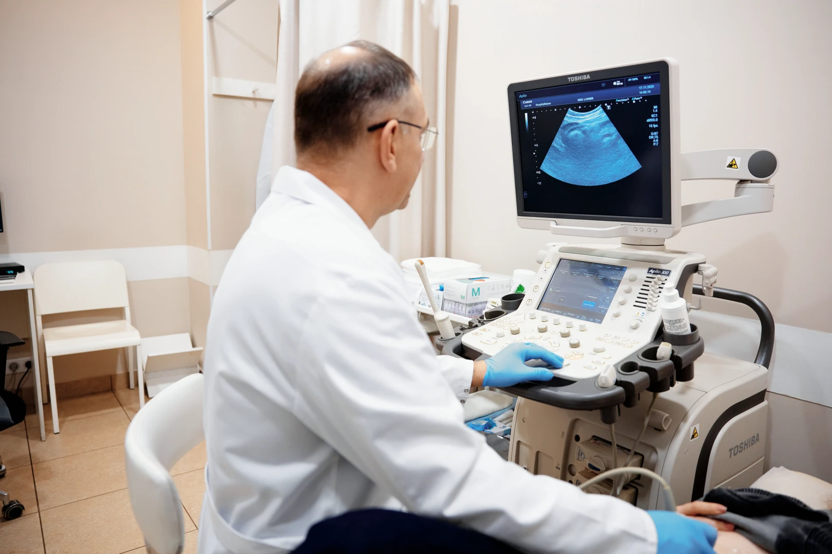 Врач разговаривает с пациентом перед УЗИ плечевого сустава