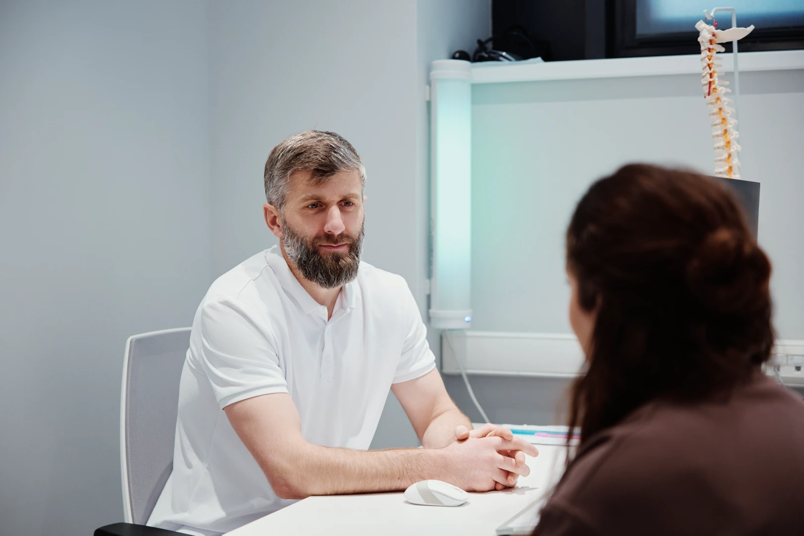 Врач беседует с пациентом после мануального массажа и даёт рекомендации по дальнейшему лечению