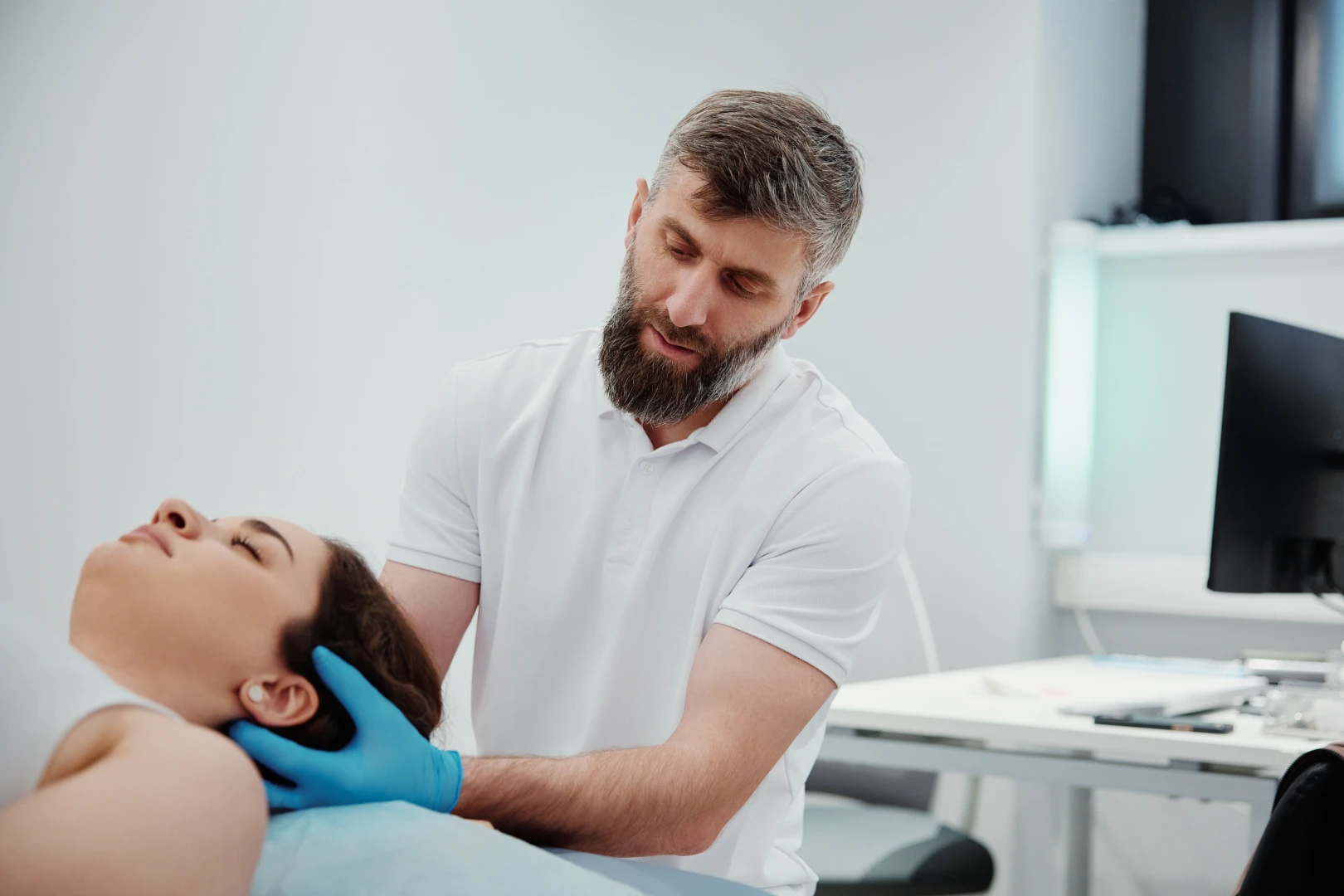 Врач проводит осмотр пациента на приеме