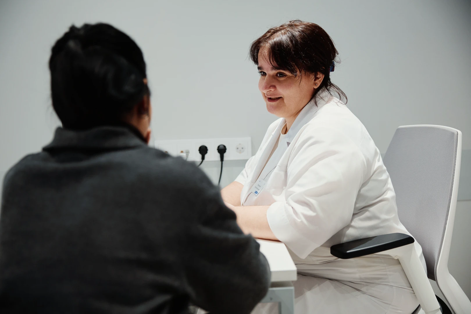 Врач-гинеколог обсуждает болезненность менструации с пациенткой