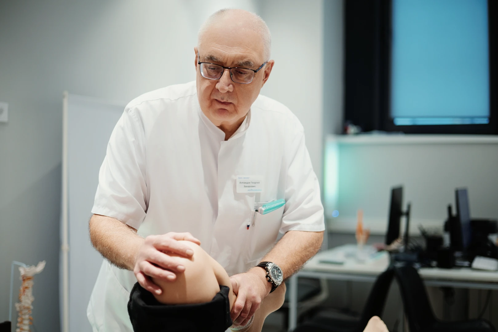 Артролог проводит осмотр пациента в Ист Клинике