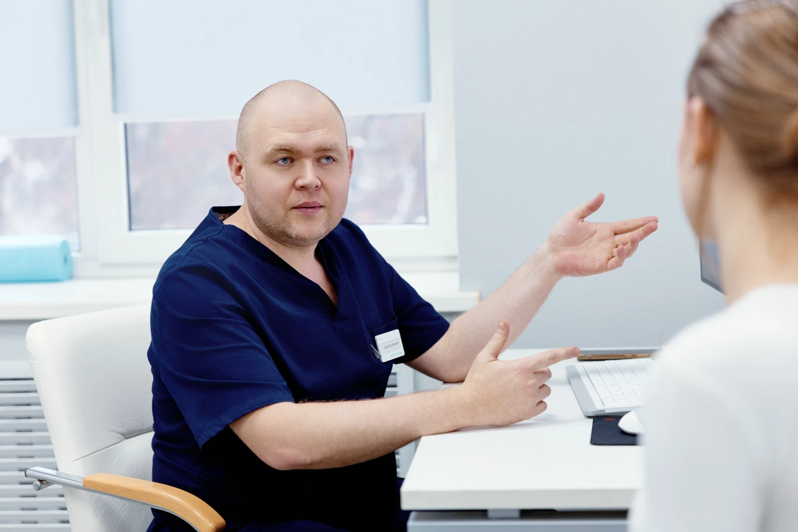 Мануальный терапевт беседует с пациентом перед проведением процедуры