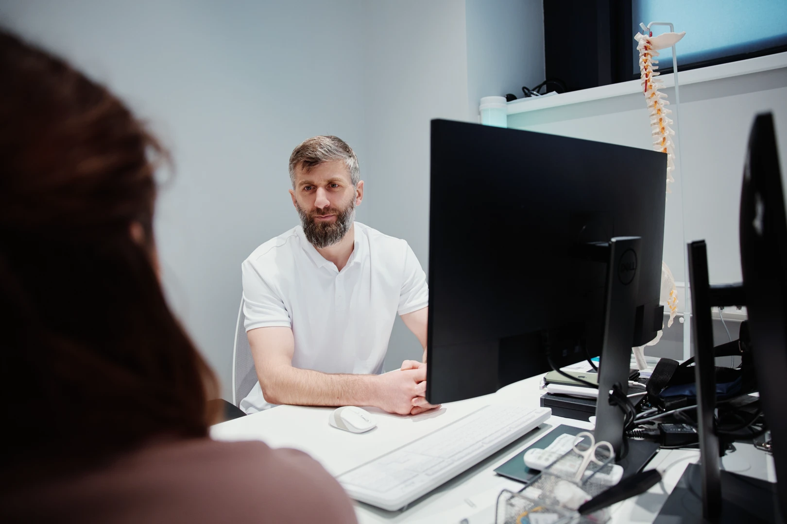 Мануальный терапевт обсуждает с пациентом результаты терапии и даёт рекомендации по лечению