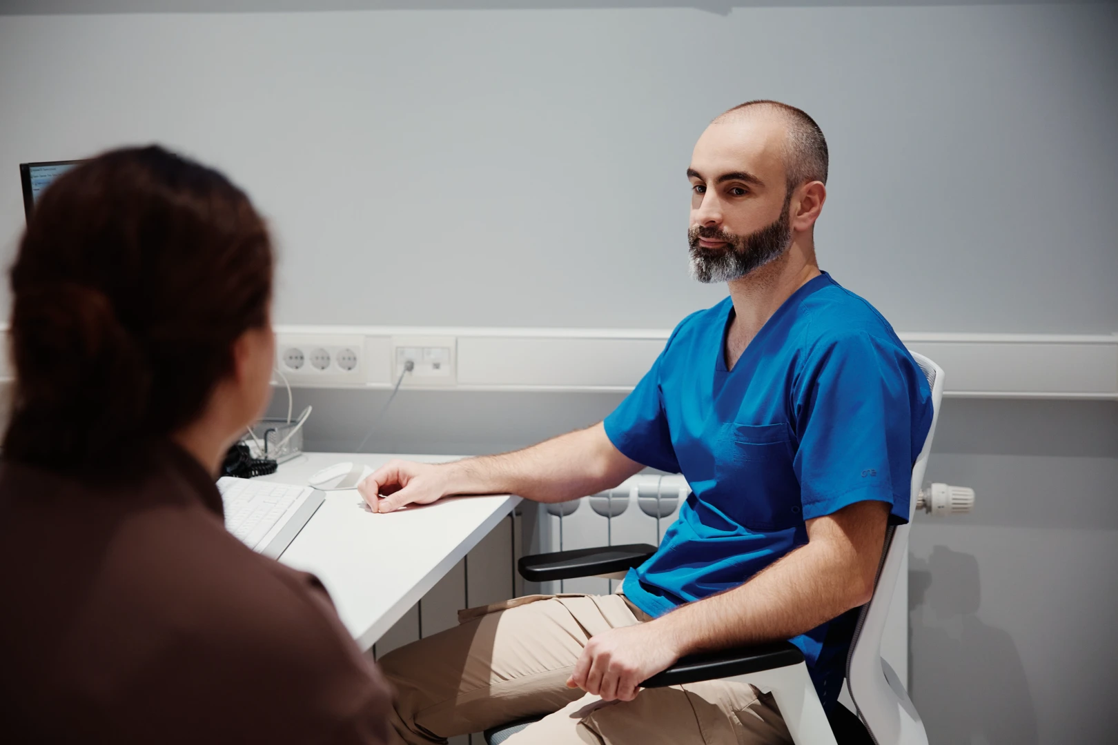 Врач беседует с пациентом и обсуждает процесс миофасциального массажа