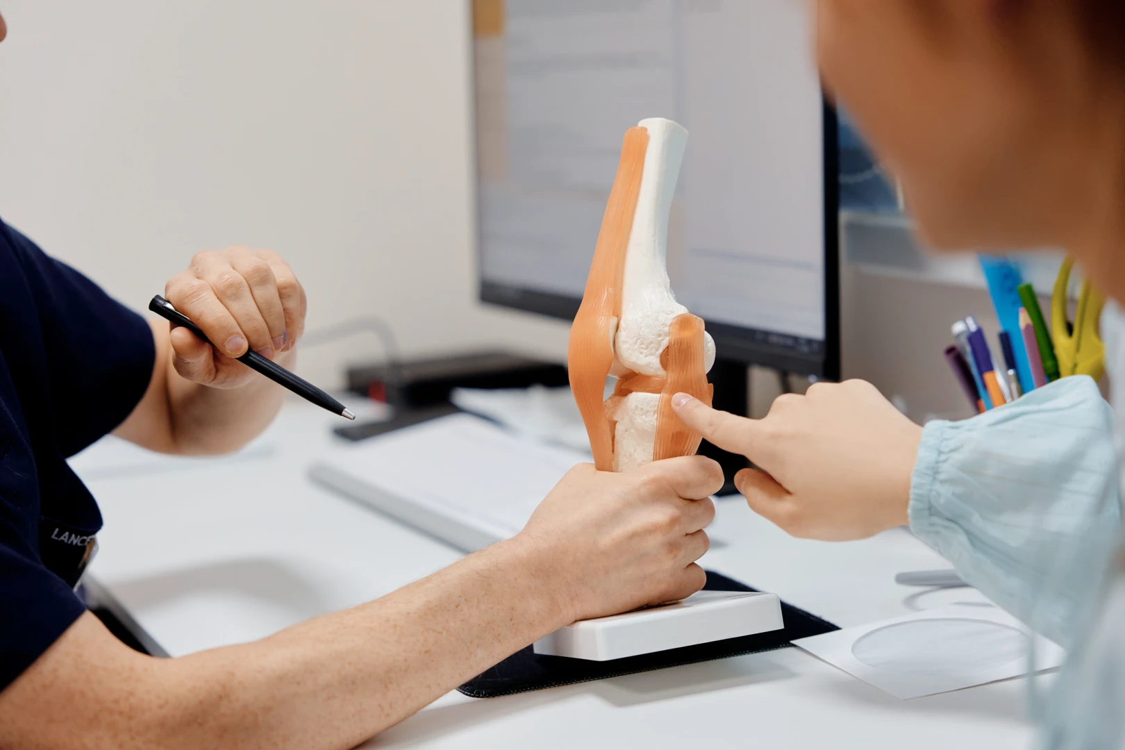 Артролог проводит консультацию и осмотр пациента на приёме