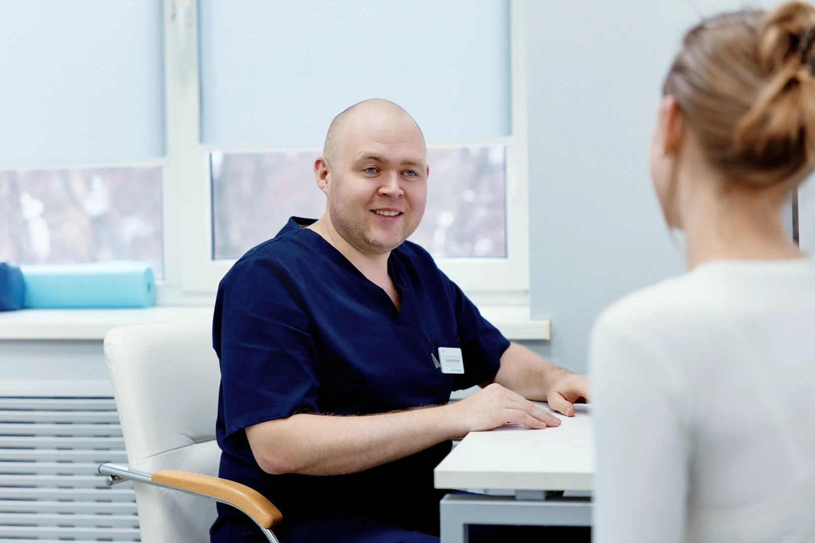 Остеопат беседует с пациентом на приёме