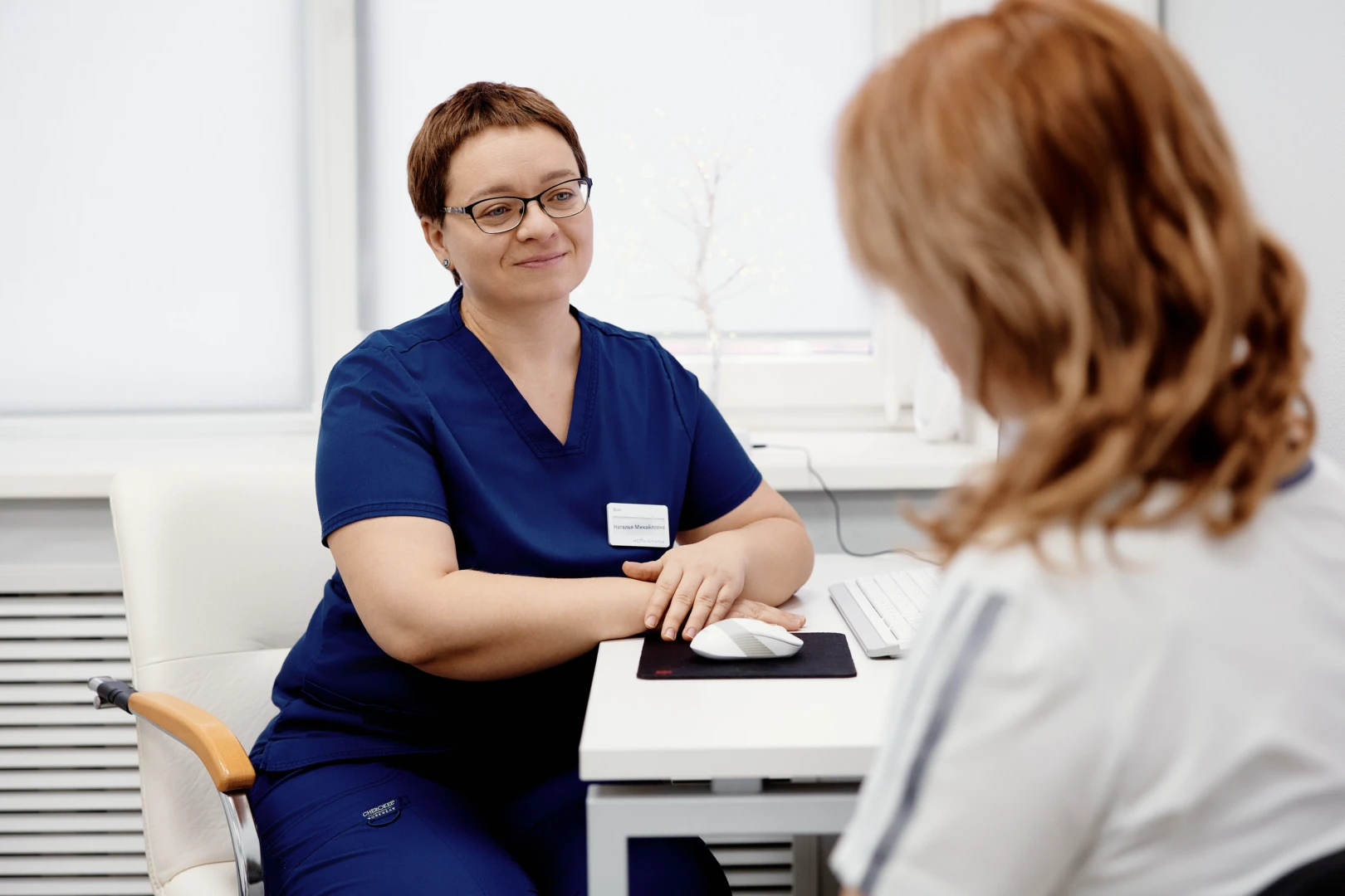 Остеопат беседует с пациентом перед проведением остеопатического массажа