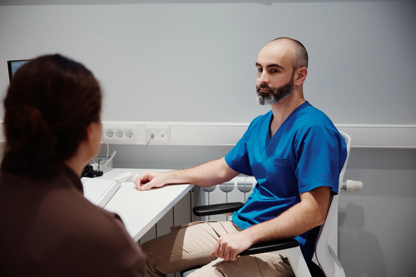 Врач-реабилитолог проводит консультацию и осмотр пациента в Ист Клинике