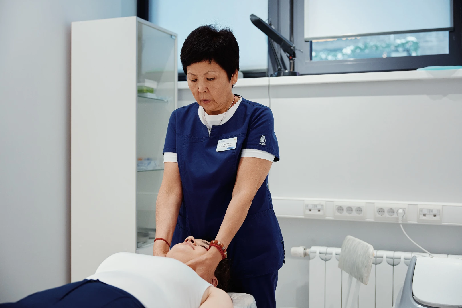 Остеопат проводит остеопрактику пациенту в Ист Клинике