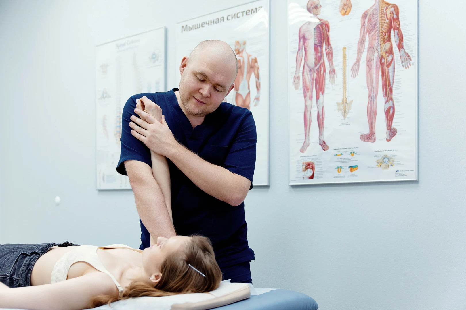 Врач осматривает и проводит сеанс структуральной остеопатии