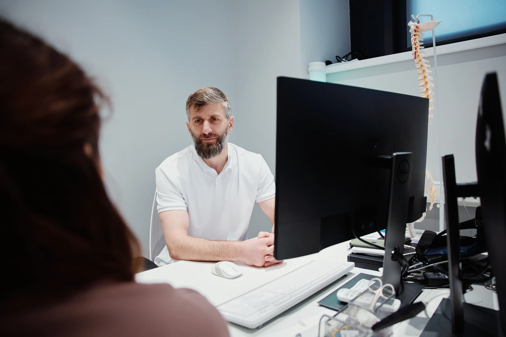 Остеопат проводит консультацию с пациенткой перед сеансом