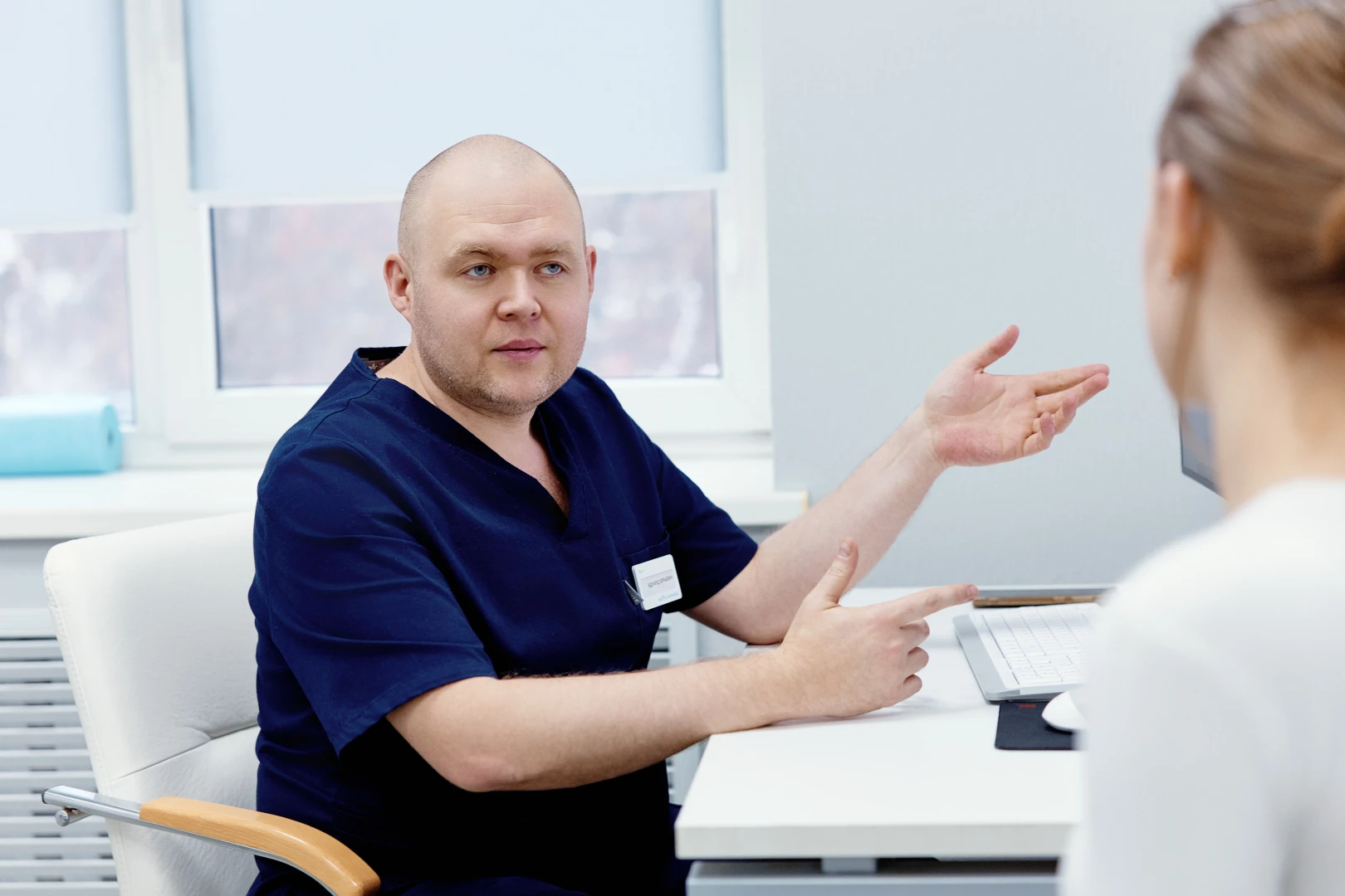 Остеопат беседует с пациентом перед коррекцией