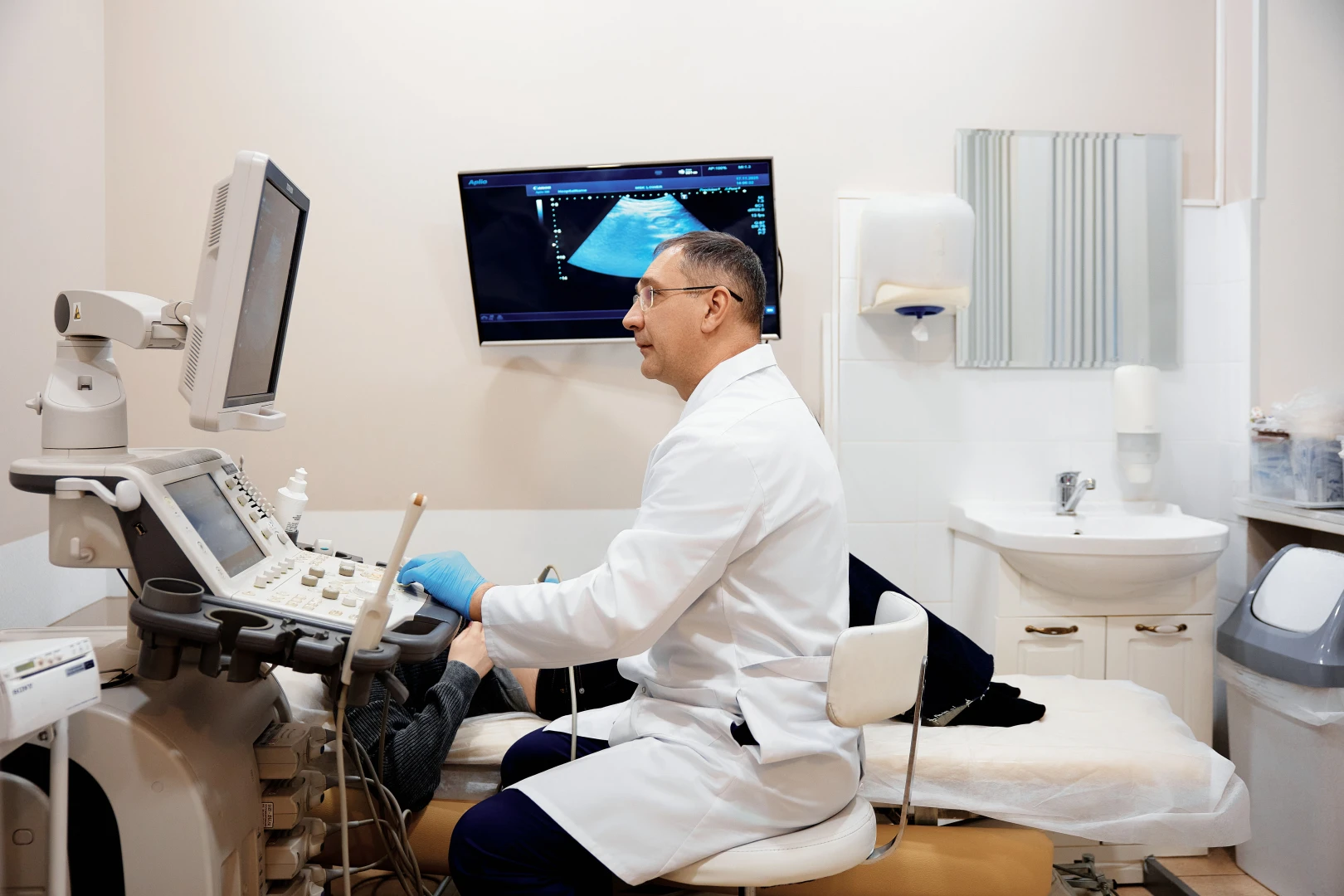 Врач проводит дуплексное сканирование сосудов шеи