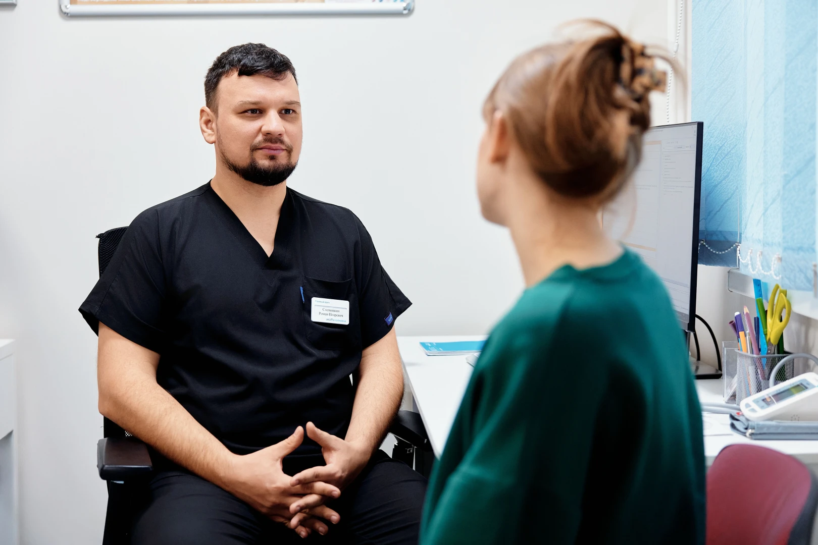Врач-невролог общается с пациентом на приёме в Ист Клинике
