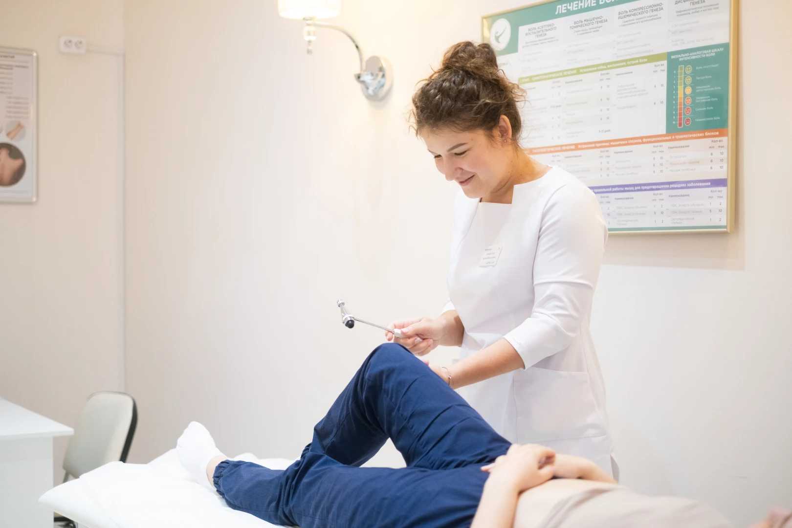 Врач-невролог проверяет рефлексы у пациента на приёме перед назначением лечения