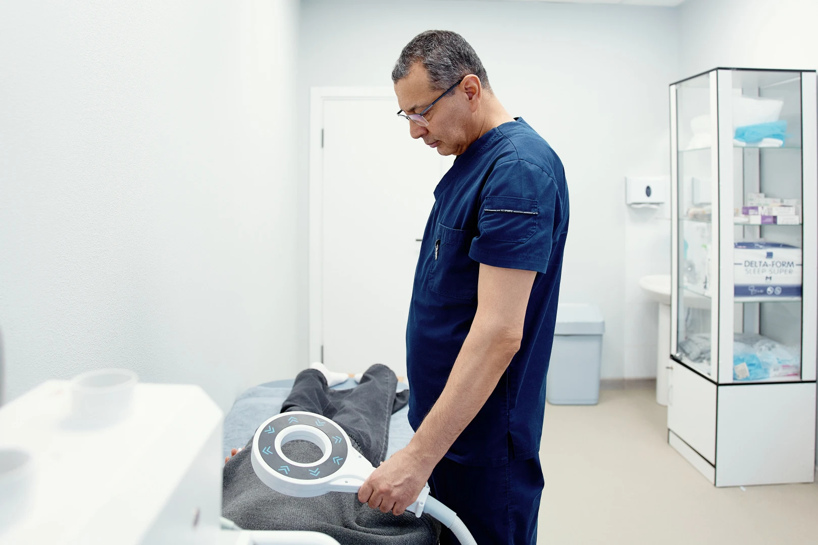 Врач-уролог проводит процедуру пациенту перед лечебной физкультурой