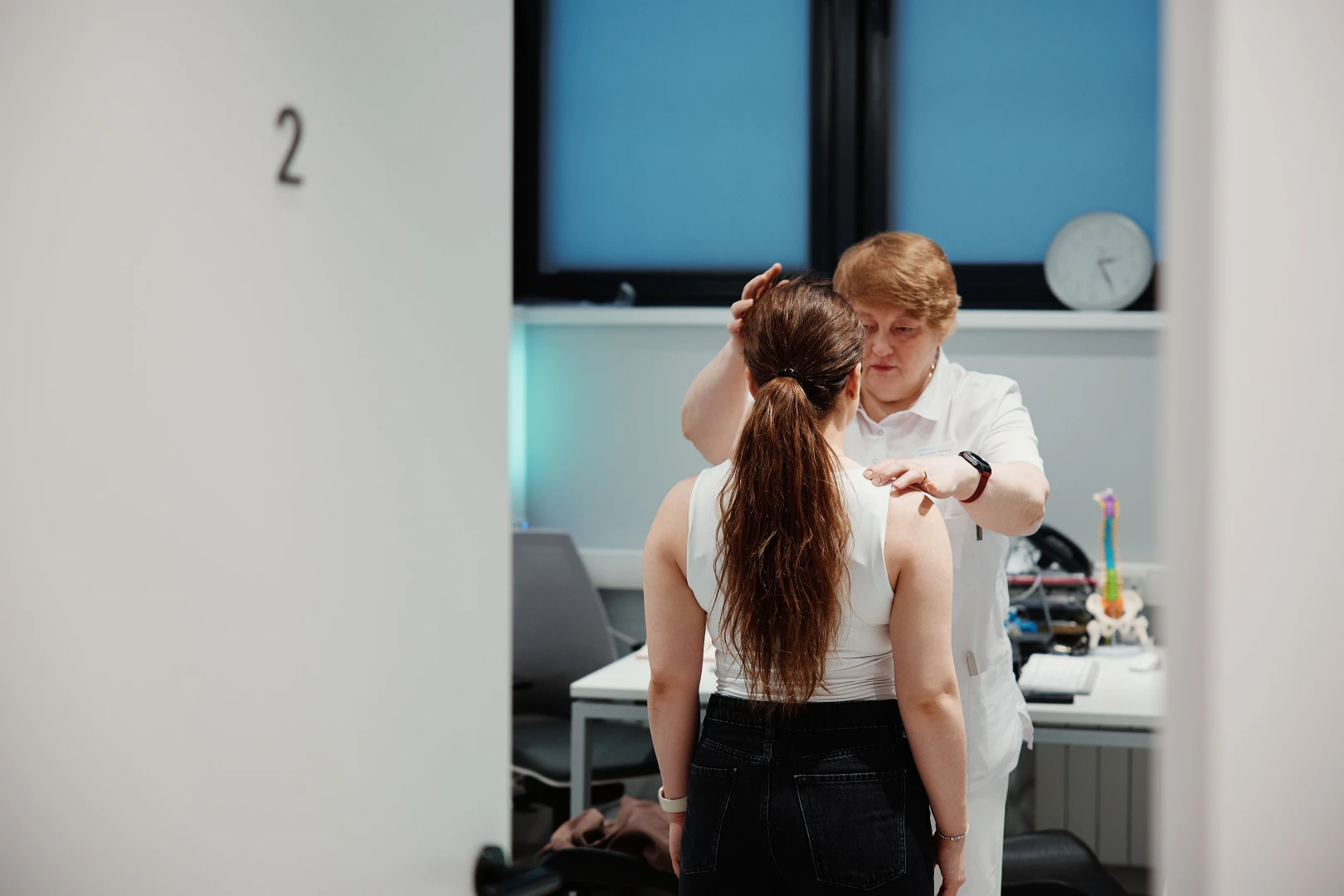 Врач-невролог проводит осмотр пациента перед проведением лечения