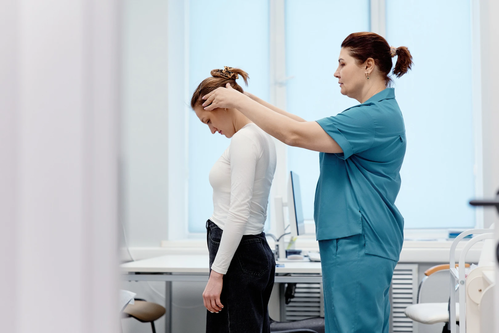 Невролог осматривает пациента на приёме, чтобы найти причину головной боли