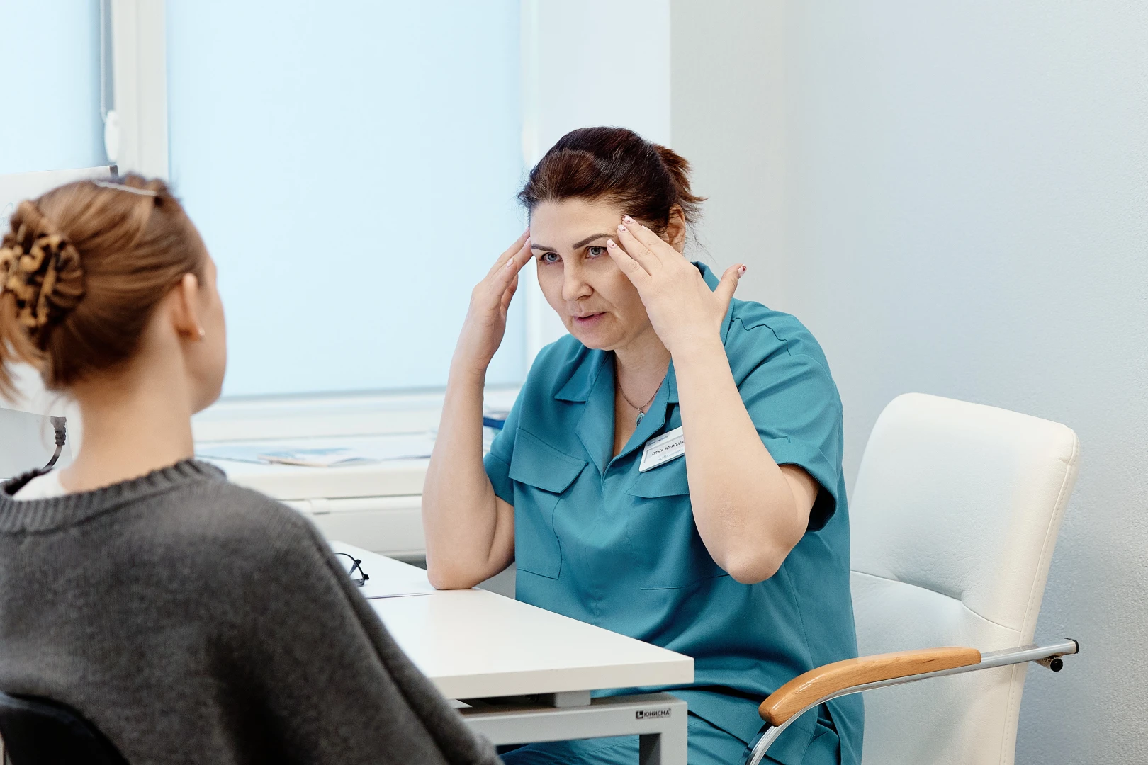 Невролог проводит консультацию пациенту при головной боли