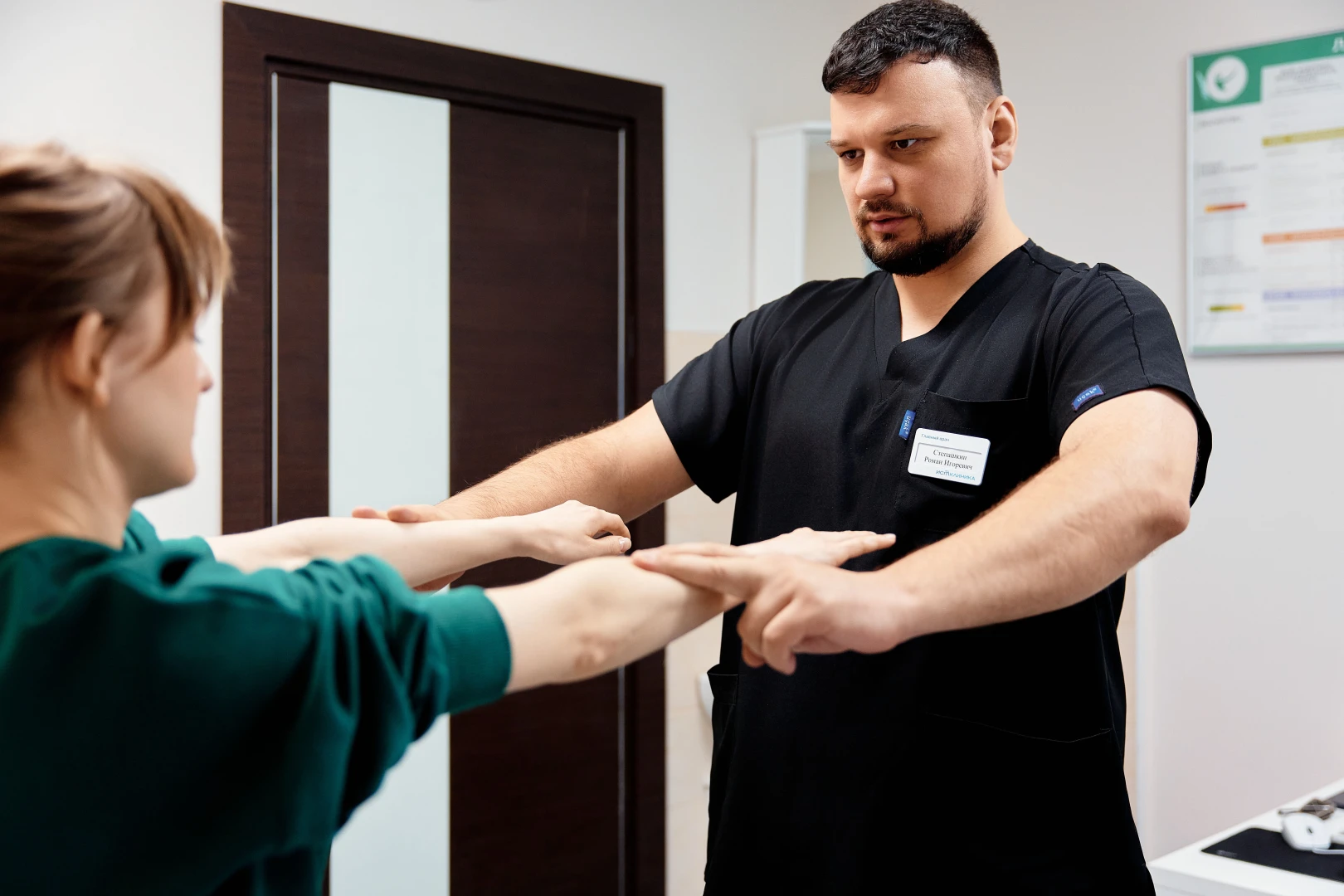 Невролог проводит осмотр пациента на приёме в Ист Клинике