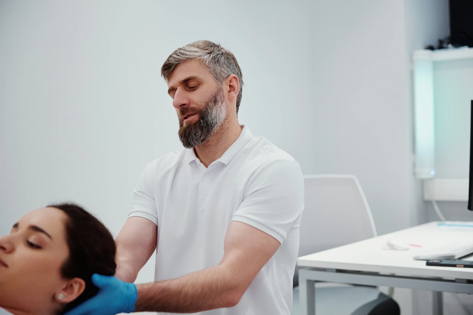 Невролог проводит осмотр пациента при головной боли