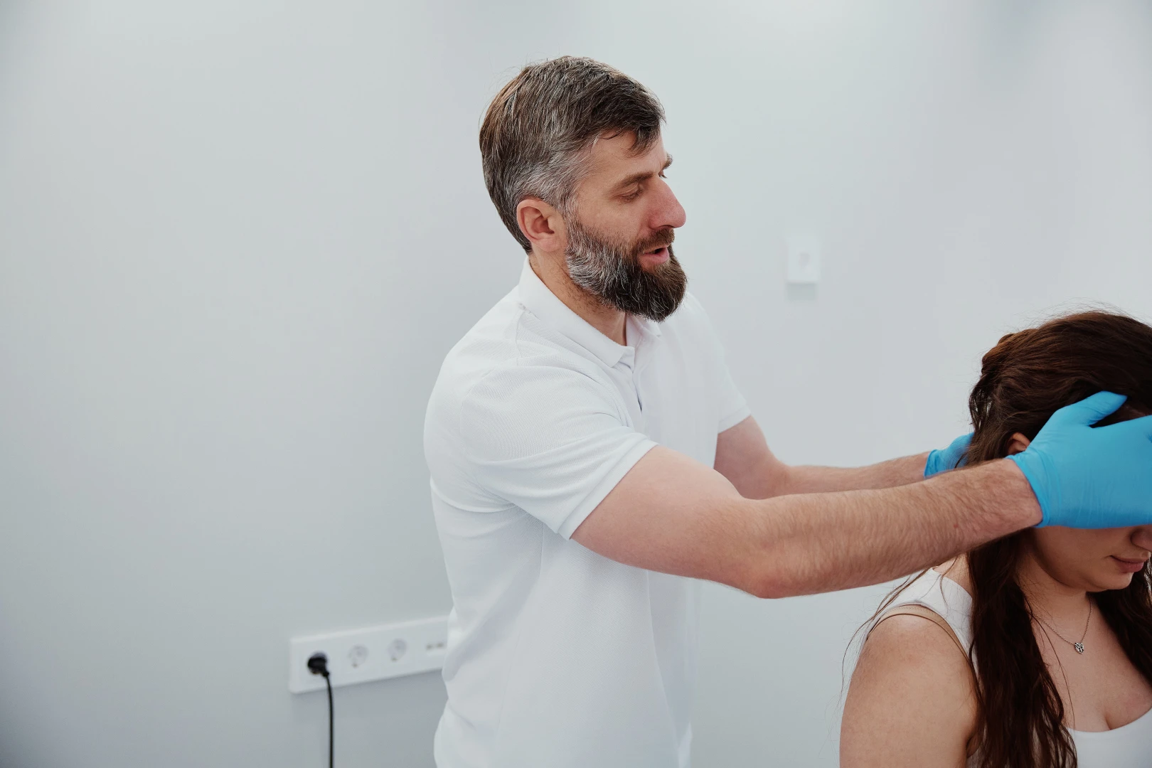 Остеопат мягко работает с шеей пациента