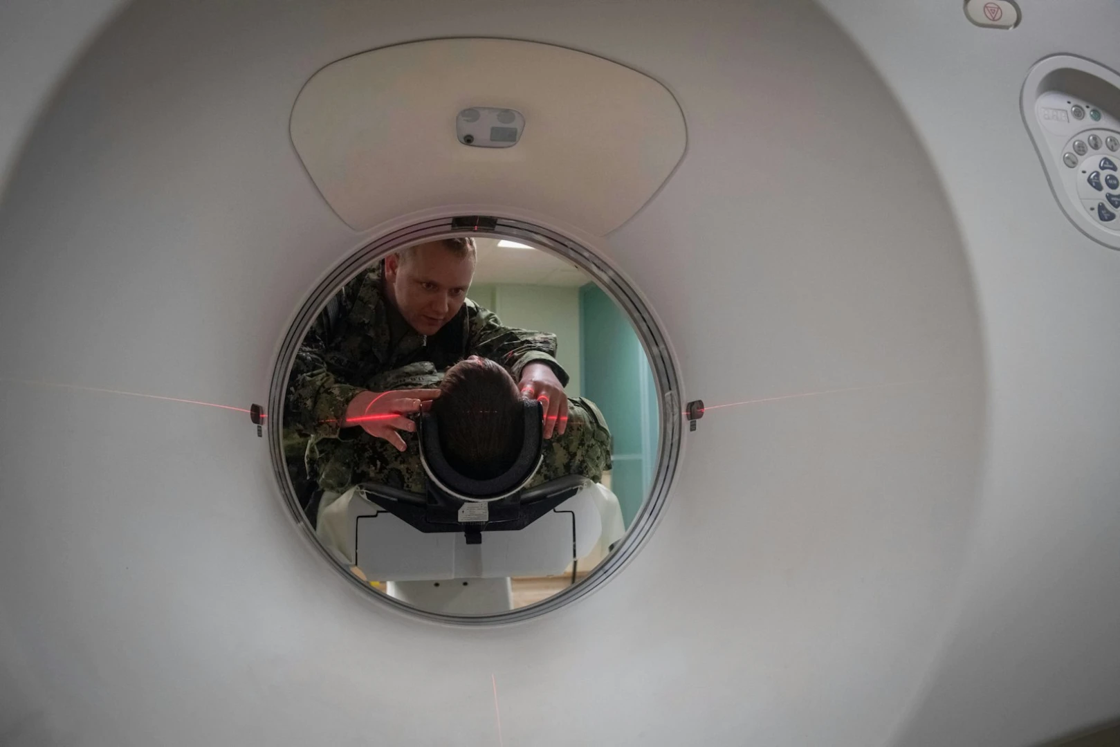 Пациента укладывают в компьютерный томограф, лазерная разметка помогает точно позиционировать зону сканирования