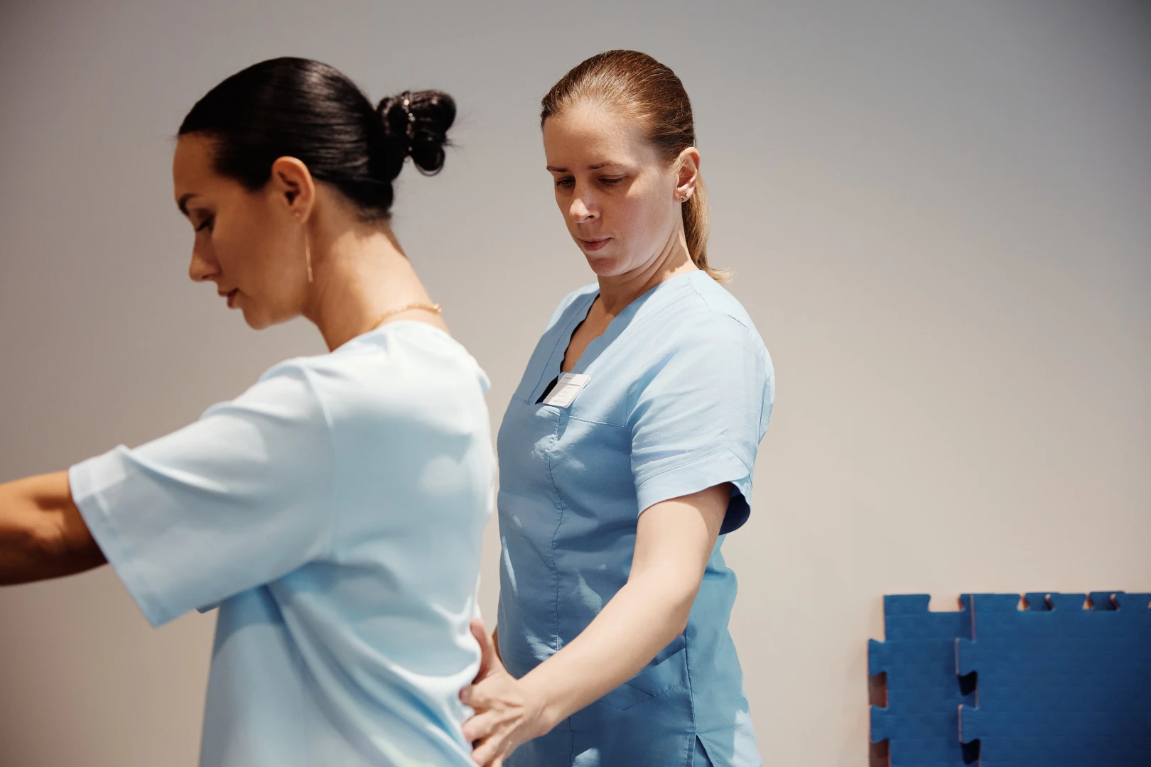 Специалист придерживает поясницу и таз, показывая правильное положение корпуса
